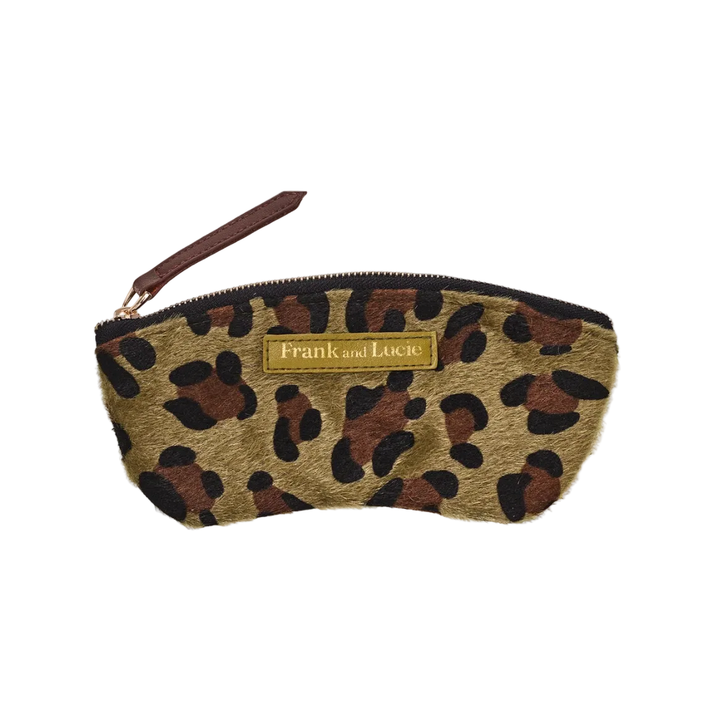 A small zip pouch with a leopard print pattern in tan, brown, and black, featuring a gold brand plaque that reads 'Frank and Lucie' and a brown wrist strap, shown on a plain white background.
