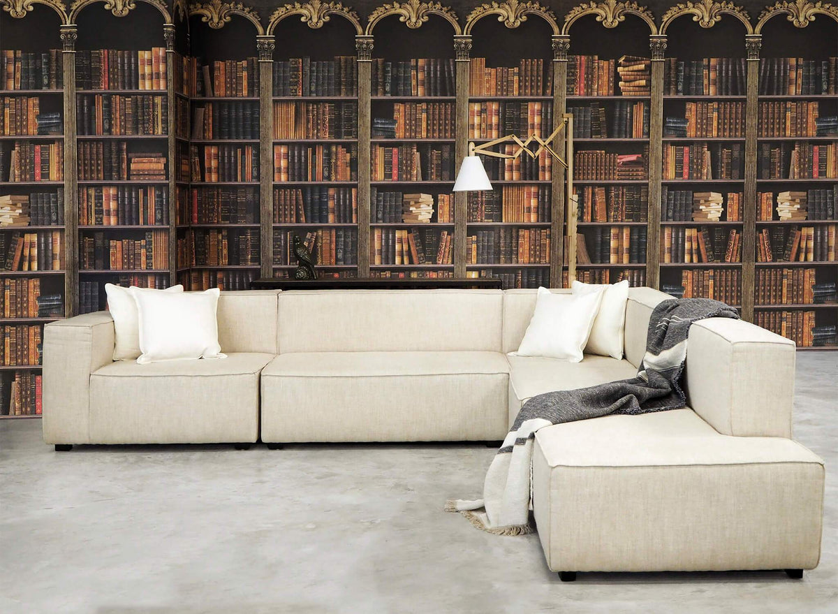 A cream modular sofa in front of floor-to-ceiling bookshelves